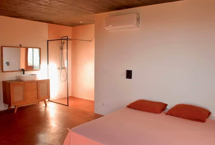 Esta habitación tiene dos camas de 0,90m que se pueden convertir en una cama de 1,80m bajo petición. Tiene dos taburetes, dos lámparas de cama, un mueble con cajones para la ropa, un armario, un largo borde de pared para colocar objetos.