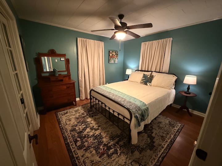 El dormitorio de invitados cuenta con una cama tamaño queen, mesitas de noche y lámparas con enchufes USB/USB-C para cargar el teléfono, y un vestidor victoriano antiguo. Esta habitación tiene puertas francesas con vidrio esmerilado que se abren al tercer dormitorio. 