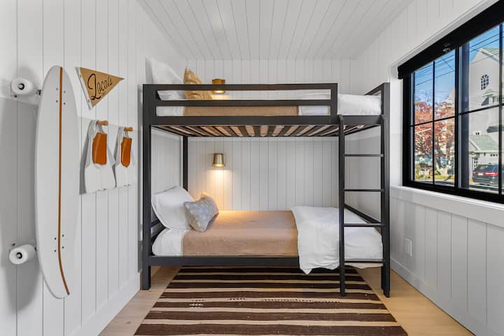 El dormitorio cuenta con dos camas individuales con apliques de lectura, persianas opacas y una decoración súper elegante. 