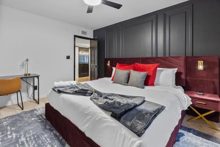 חדר שינה גדול ונועז עם חיפויי קיר בהתאמה אישית, מרקמים עשירים וחלל עבודה ייעודי - מעוצב לנוחות, מיקוד ושינה נהדרת.