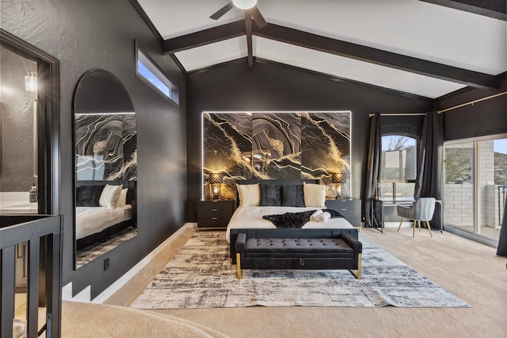 הסוויטה הראשית במלוא הדרה - תקרות מקומרות, קיר אומנות LED בהתאמה אישית, מיטת קינג סייז הממוקמת במרכז הנוף, ושלווה שמרגישה גם דרמטית וגם משקמת.