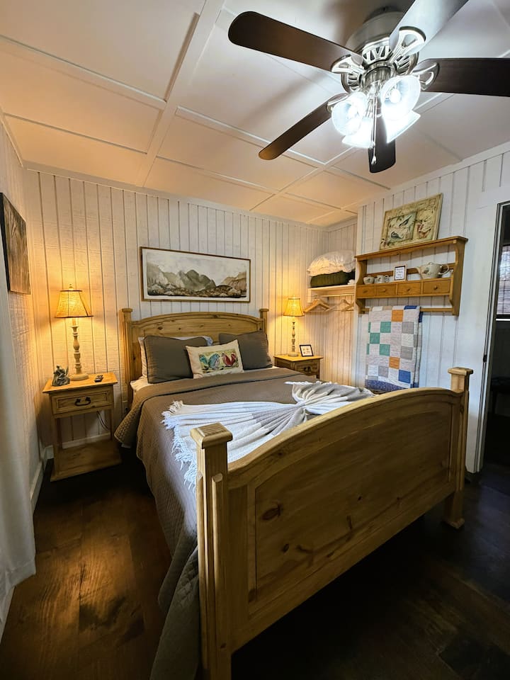 Ова е втората спална соба на главниот кат со брачен кревет (широк 150-179 см).  Прозорецот гледа кон задната веранда.  Старото ќебе е само за украс, но обезбедуваме дополнително удобно ќебе за секој кревет. Оваа спална соба има сопствена бања, комода и телевизор.