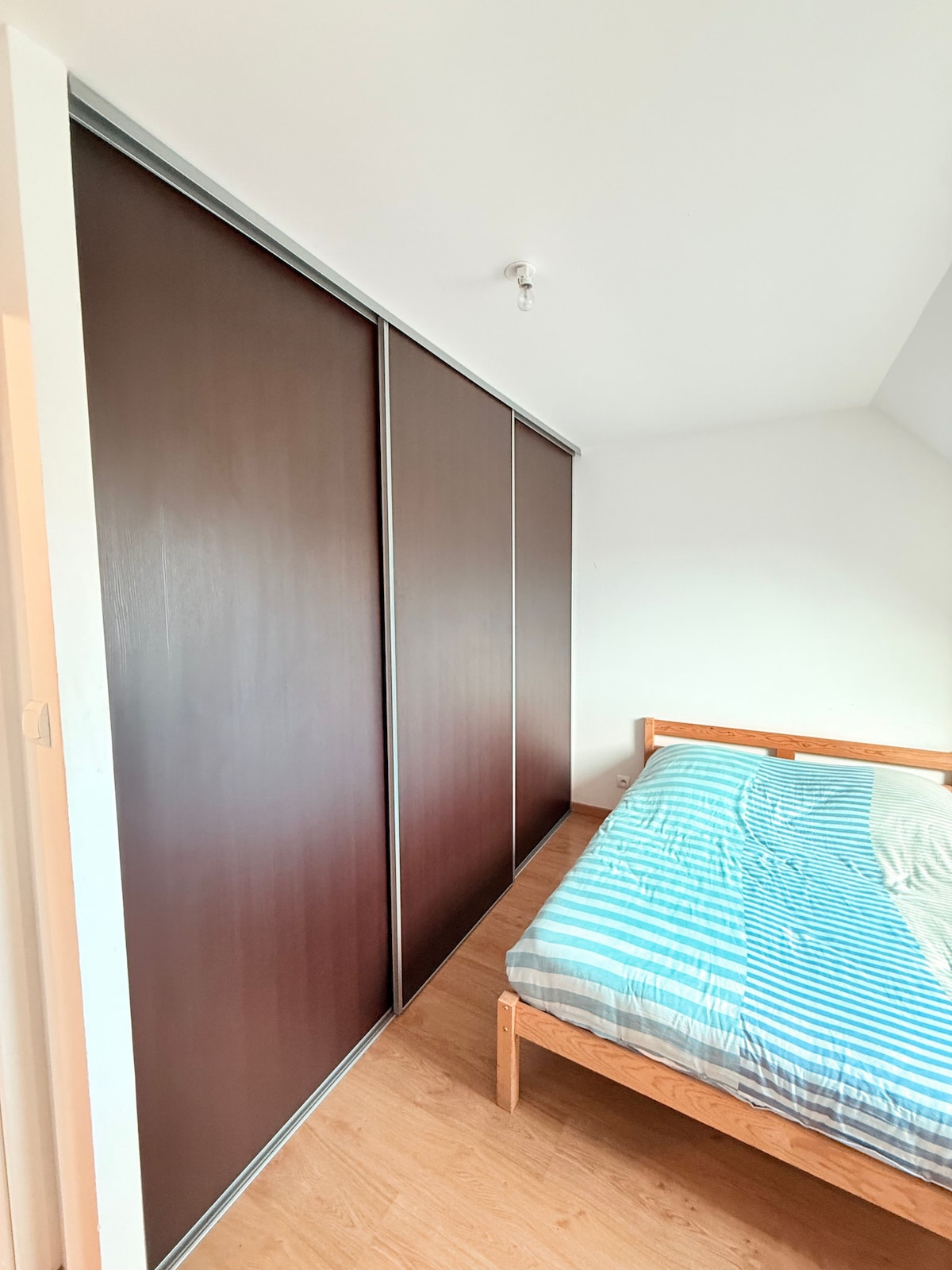 Spálňa s veľkým 4-metrovým posuvným šatníkom, ideálnym na uloženie všetkých vašich vecí. Svetlý priestor a pohodlná posteľ pre príjemný pobyt.