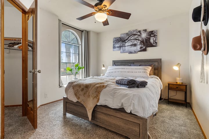 ห้องนอนมุมธีมโบโฮพร้อมเตียงควีนไซส์และโคมไฟแขวน