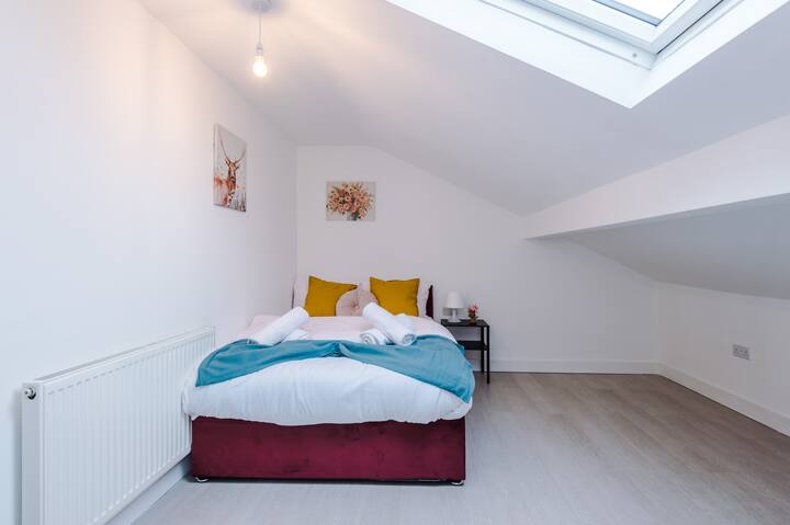 Cozy attic bedroom with skylight and comfortable bedding