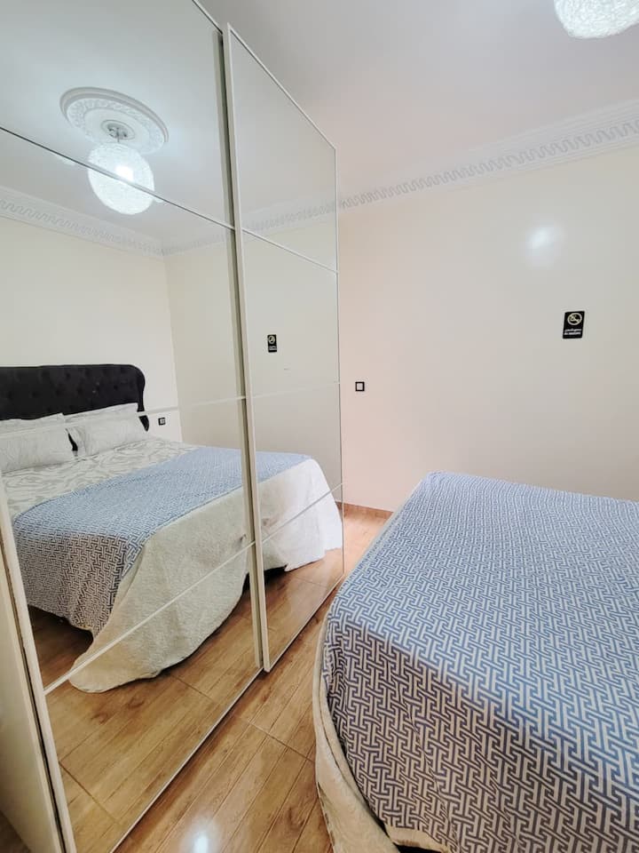 غرفة نوم رئيسية بسرير بمقاس كبير. مساحة مشرقة لشقة عالية المستوى للإيجار في دار بوعزة.