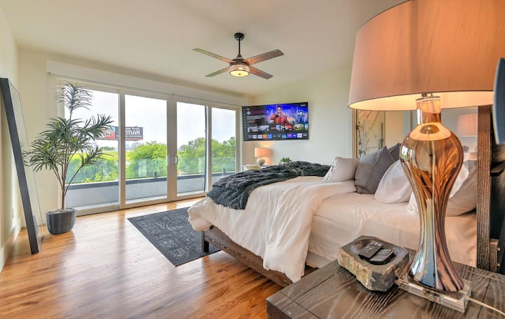 Bright bedroom with cozy king bed, streaming TV, floor-to-ceiling windows, and modern decor—perfect for unwinding.