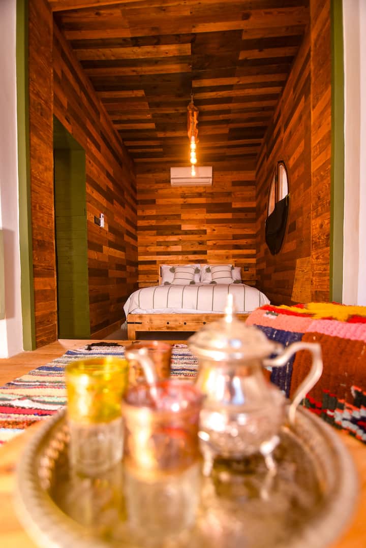 Queen-size bed with air conditioning available. First-ever room built on the farm and pillar of sustainability.