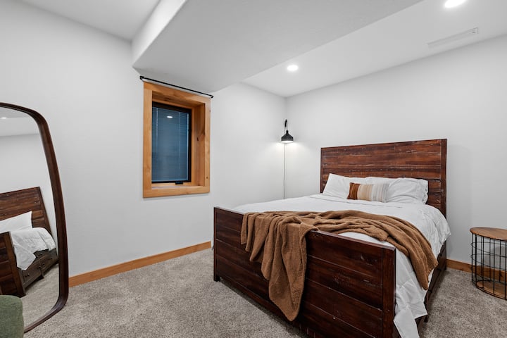 Sekundárny apartmán ponúka svieži, moderný kontrast so svojimi jasnými bielymi stenami a elegantným nábytkom z tmavého dreva.