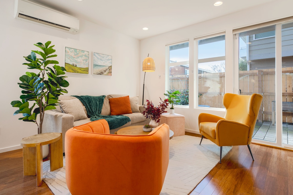 Sala de estar luminosa y acogedora con un diseño espacioso, lujosos sofás y un televisor inteligente de 75 pulgadas, perfecto para noches de cine y relajarse después de explorar Seattle.