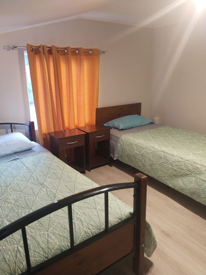 quarto com 2 camas de 1,5 quadrado, lâmpadas, cortinas escuras, com fechadura no interior e chave para proteger pertences.