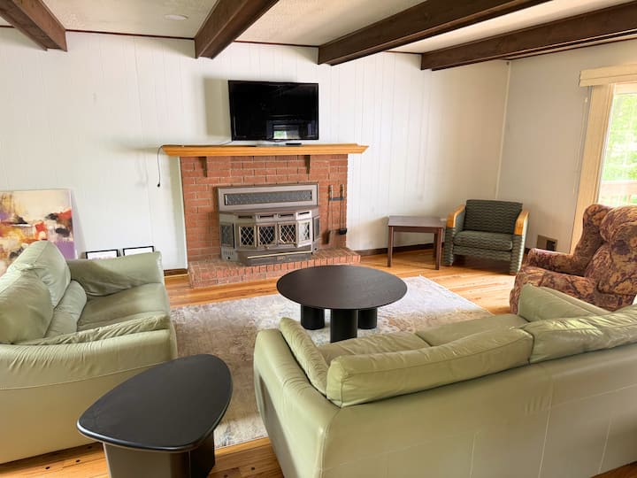 Warm, inviting living room centered around a classic brick fireplace and mounted TV perfect for relaxing nights.