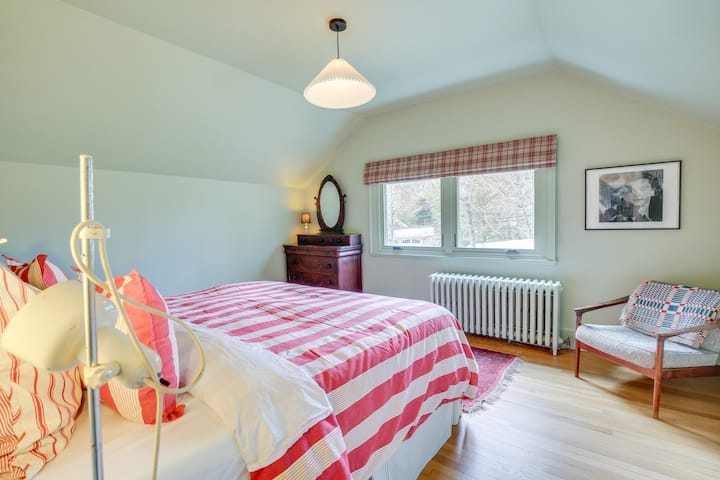 这是主卧室，配备特大号床和古董梳妆台。 还有一个挂衣服的衣橱和一把椅子。 