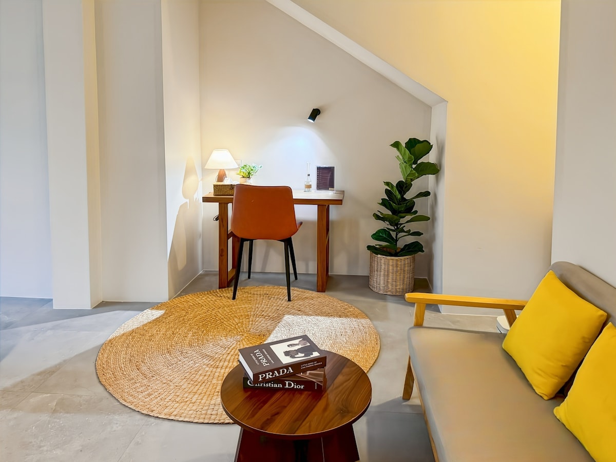 รูปแบบสตูดิโอที่กว้างขวางพร้อมโซฟา โต๊ะทำงาน และพื้นไม้