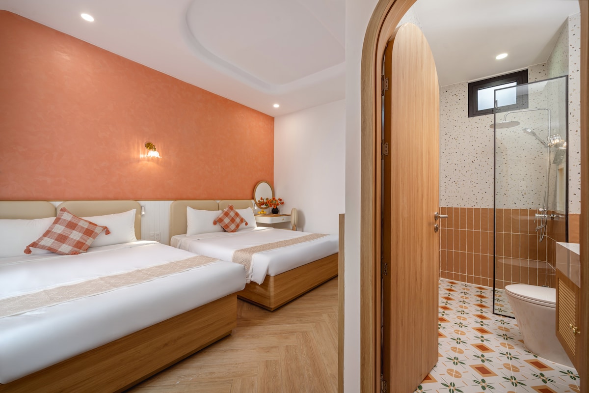 Dormitorio familiar en la parte trasera del 3er piso con dos camas king de 1,6 m, baño en suite, grandes ventanales, escritorio, televisor inteligente, aire acondicionado, armario, iluminación cálida, lámparas de lectura y ropa de cama suave de alta calidad para una estancia acogedora y relajante.