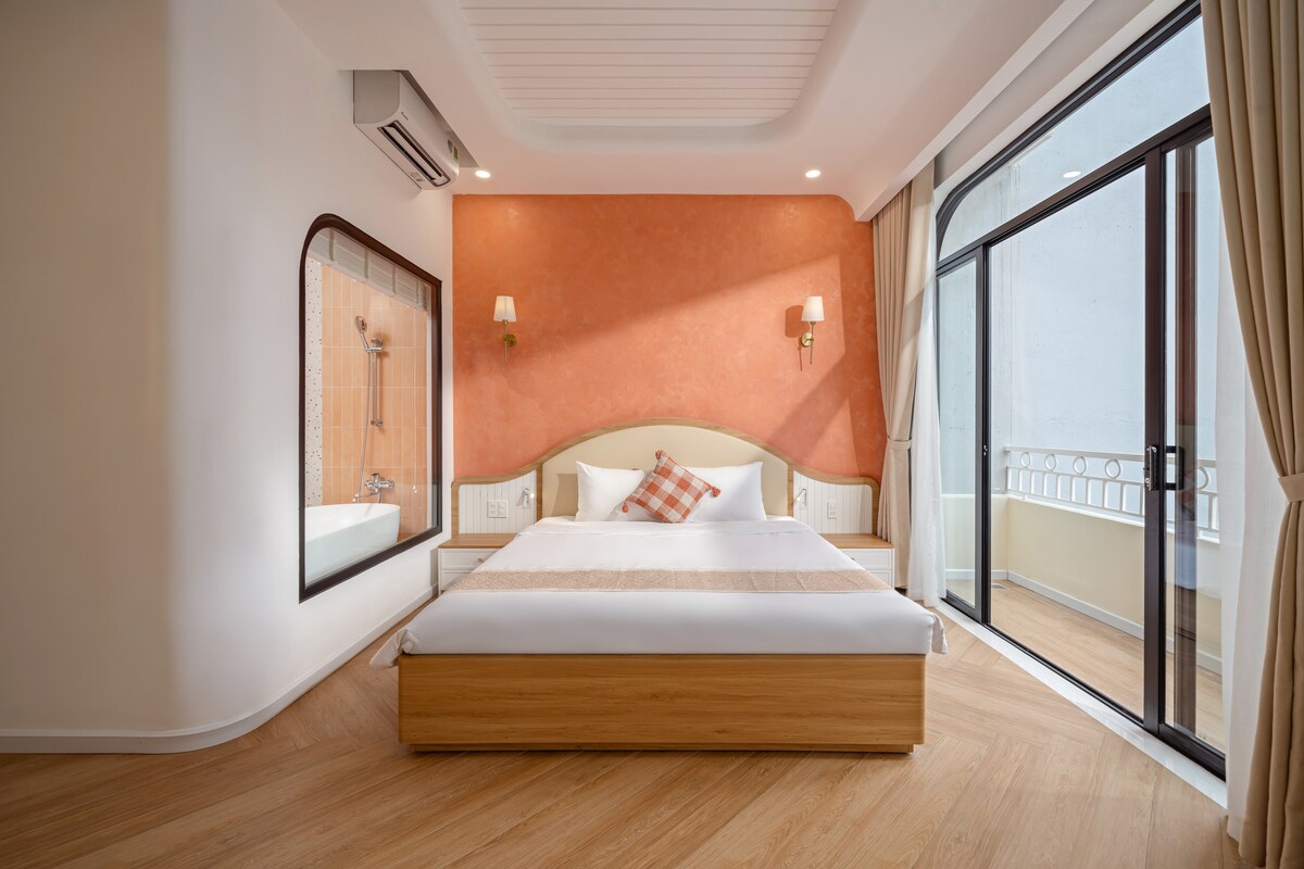 Habitación principal al frente del 2do piso con cama king de 1.8m, balcón a la calle y al patio delantero, baño en suite con bañera grande, grandes ventanales, escritorio, Smart TV, aire acondicionado, armario, iluminación cálida, lámparas de lectura y ropa de cama de primera calidad.