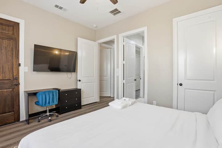 This king room includes a sleek TV setup, work-friendly desk, and storage drawers, offering a comfortable and functional space for rest and focus.
