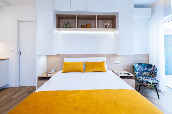 Bright and modern suite with a comfortable queen bed, cozy seating area — a perfect space for couples looking for a relaxing and romantic stay.