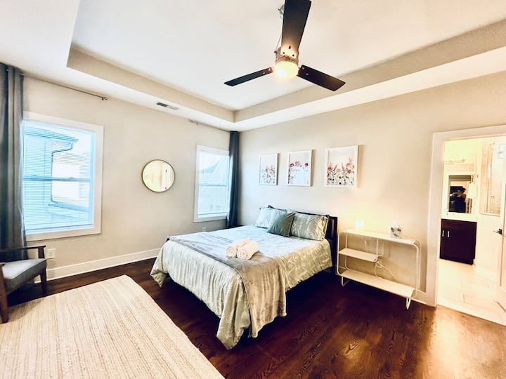 Oversized bedroom with ensuite full bathroom and walk-in closet. Sitting area with two comfortable chairs + desk and work chair. 