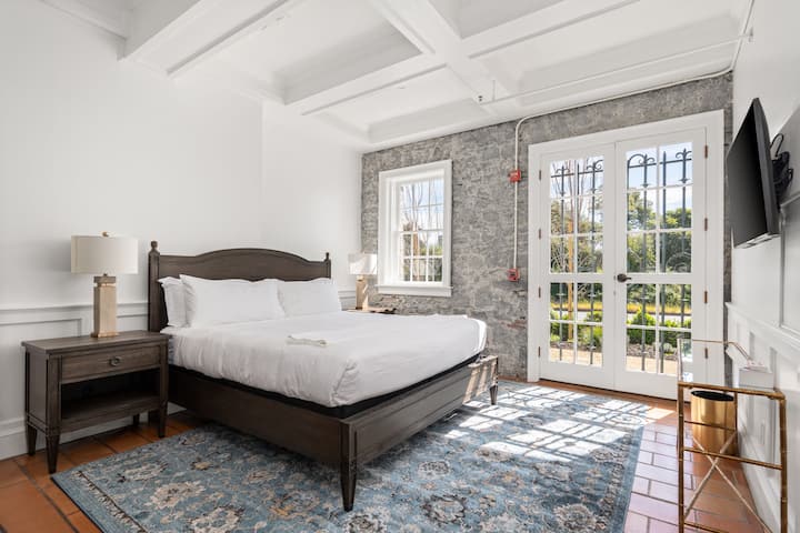 A bright private bedroom with a comfortable bed and soft natural light filling the space.
