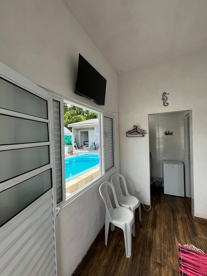 Suíte Europa: TV, frigobar e janela com vista para a piscina