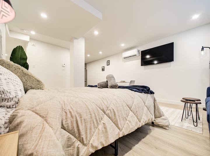 Este refugio de Montreal ofrece un dormitorio sereno con una cómoda cama tamaño queen, TV, complementado con una decoración elegante y de buen gusto que crea un ambiente relajante y acogedor.