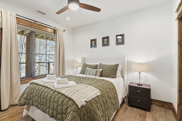 Designed for comfort in every season, this guest bedroom features a ceiling fan, cozy bedding, and tranquil tones. It’s an inviting place to relax, watch a show, or simply enjoy the quiet mountain atmosphere.