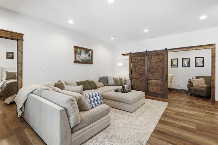 The lower-level lounge is ideal for movie nights, card games, or simply curling up after adventures outdoors. Comfortable seating and easy access to the deck make it a favorite gathering spot for families and friends.