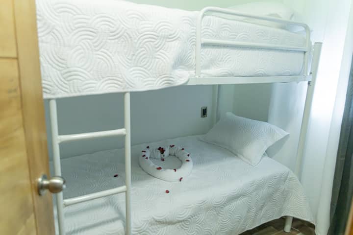 Functionele en goed onderhouden kamer, uitgerust met een stapelbed, wit beddengoed en een praktisch ontwerp dat gebruik maakt van de ruimte. Ideaal voor kinderen, gezinnen of kleine groepen, met comfort en een nette sfeer om te rusten.