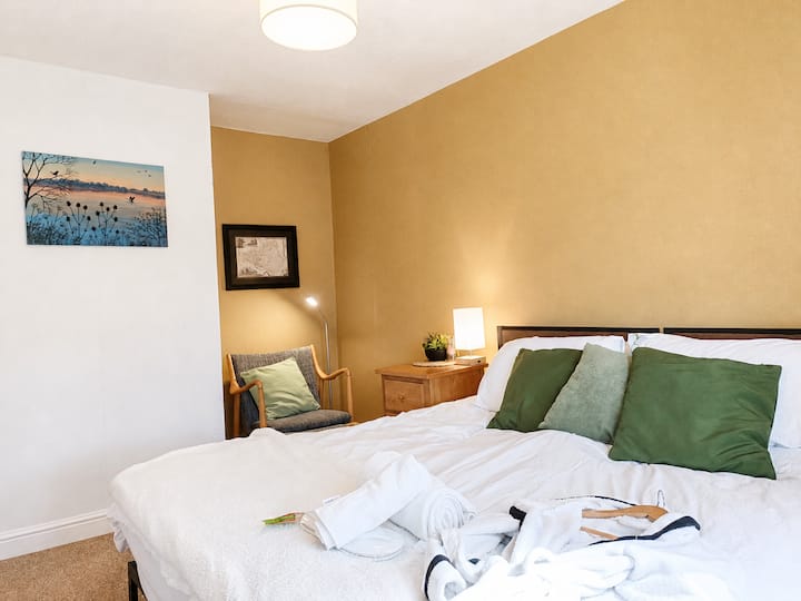 Romantic Master Suite with views of the willow tree and stream. Featuring a Super King bed, cosy reading nook, wardrobe, dressing table, and luxurious robes and slippers. Ideal for couples or friends seeking a serene, indulgent stay.