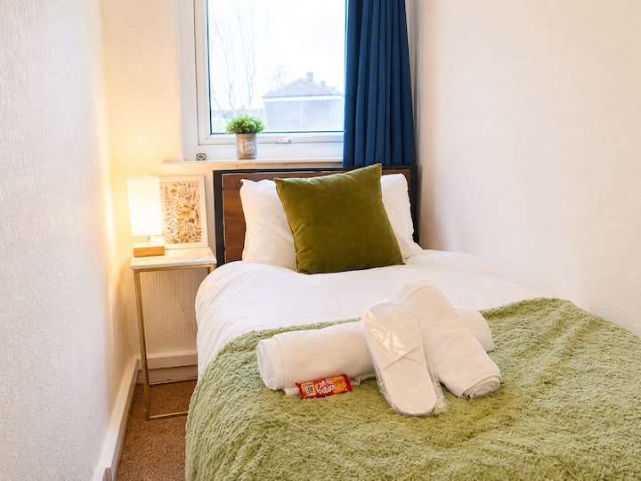 Bijou single streamside room featuring hotel-style bedding, a full-length mirror, plush robe, slippers, cosy throw, and a USB bedside lamp. A peaceful, refined space ideal for solo travellers, teens, or children