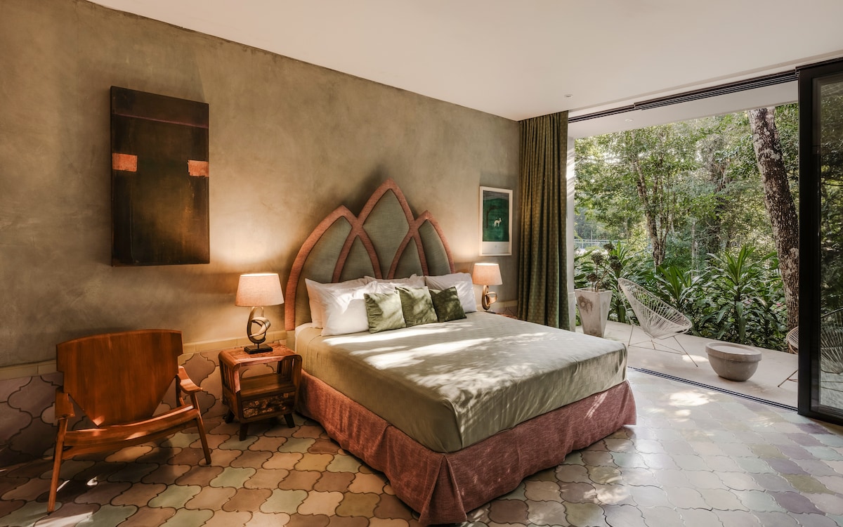 The lush fourth bedroom is a symphony of harmonious greens, with jungle views and a patio overlooking your private tennis court.
