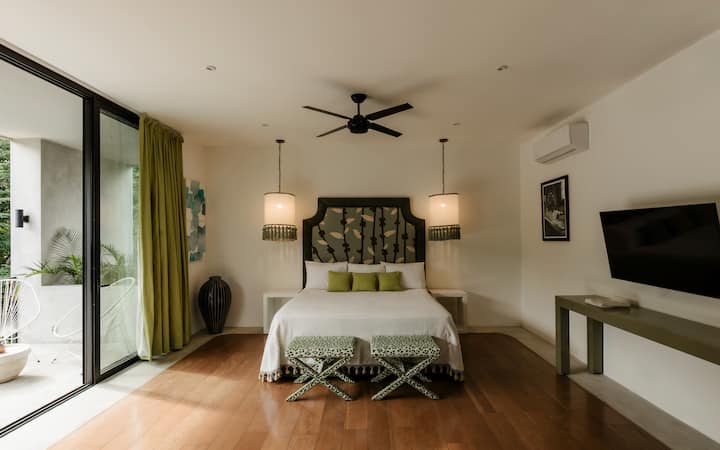The master bedroom features a king bed and a spacious balcony with serene jungle views, creating a fabulous private retreat.

