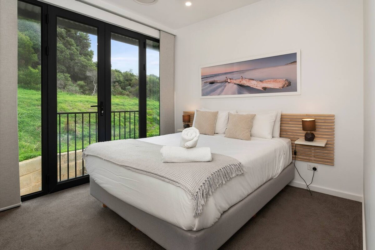 ห้องนอนควีนไซส์ที่สองที่ตกแต่งอย่างสวยงามมองเห็นสภาพแวดล้อมที่เขียวชอุ่มและมีประตูฝรั่งเศสเพื่อให้ลมพัดผ่าน