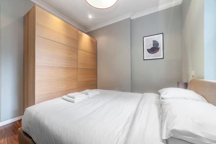 El dormitorio ofrece un refugio sereno con su cálida iluminación y su cómoda cama doble. La ropa de cama y las almohadas suaves garantizan noches de descanso después de días ajetreados en Londres.