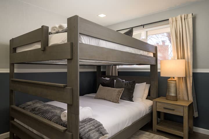 Acogedora habitación con literas, camas tamaño queen, almohadas mullidas y una iluminación cálida. Un refugio cómodo ideal para familias o grupos.