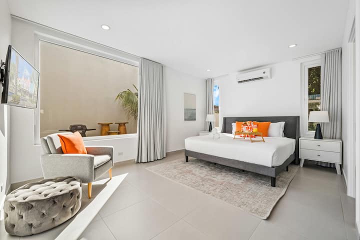 Détendez-vous dans la suite avec lit King Size, vue sur l'océan et linge de lit doux pour des nuits reposantes à Palm Beach