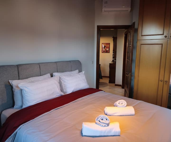 Dormitorio cómodo y luminoso con cama matrimonial y ventanas con vistas a la montaña y al casco antiguo. Tiene aire acondicionado, armarios empotrados y un ambiente tranquilo para una estancia relajante.