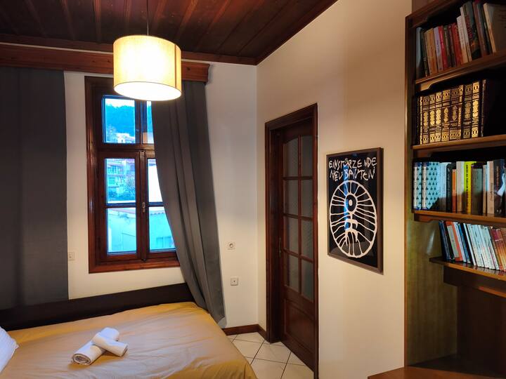 Habitación luminosa y tranquila con una cama cómoda, techo de madera y ventana con vistas a la montaña. Ambiente cálido, biblioteca y detalles cuidados para una estadía relajante.