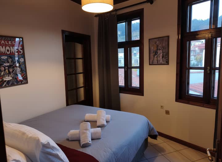 Dormitorio luminoso con una cómoda cama doble y grandes ventanales con vistas a la montaña. La decoración cálida, la luz natural y un ambiente tranquilo crean las condiciones ideales para descansar y relajarse.