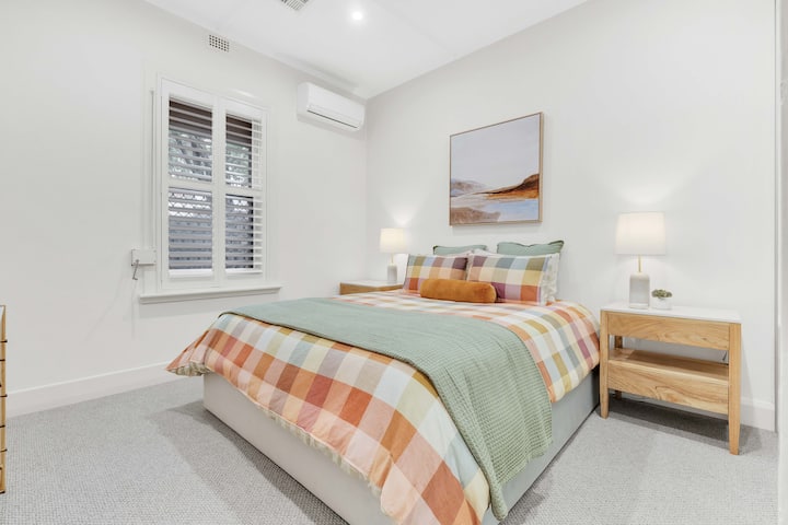 Prostrana, svijetla spavaća soba s velikim bračnim krevetom, komodom, ormarom, pametnim televizorom i klima-uređajem