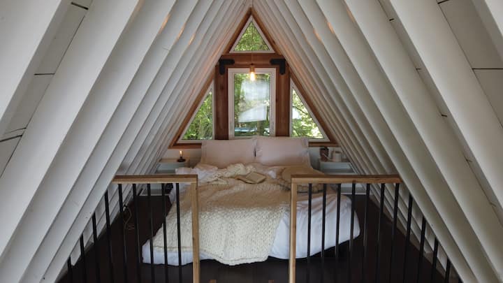 Спалня на таванско помещение, до която се стига със стълба.