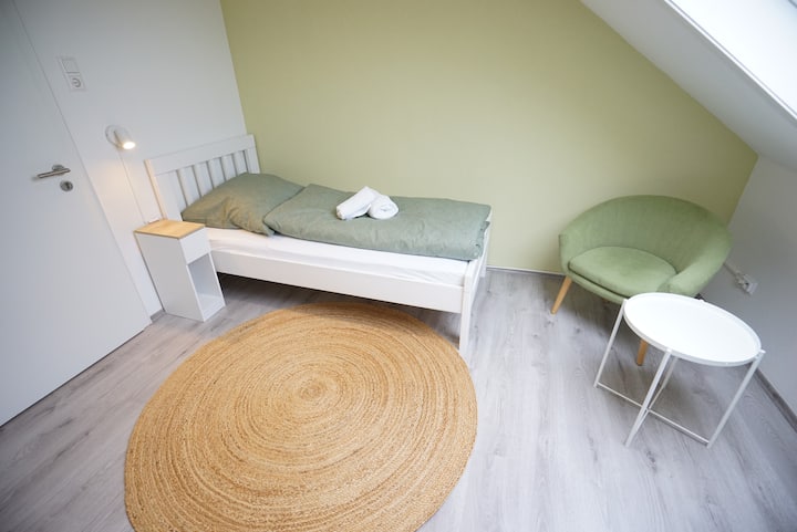 Cama individual (90 x 200 cm) con acogedora sala de estar.