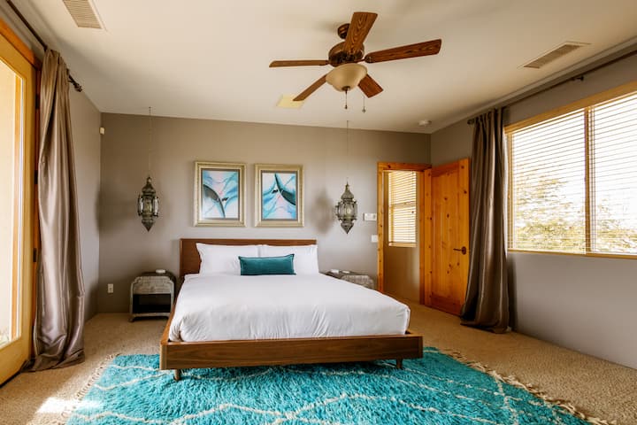 Spacious upstairs bedroom featuring a king bed and direct access to a private balcony.