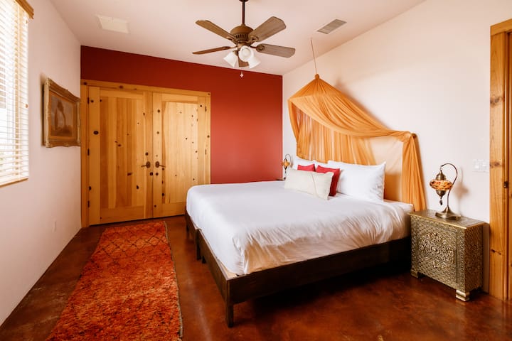 Second king bedroom designed with warmth, texture, and vibrant color.
