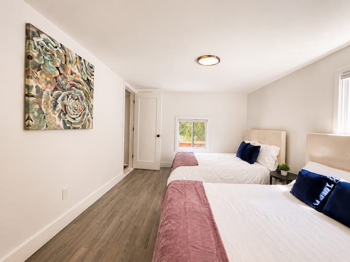 Bright bedroom with two beds and space for families or friends.