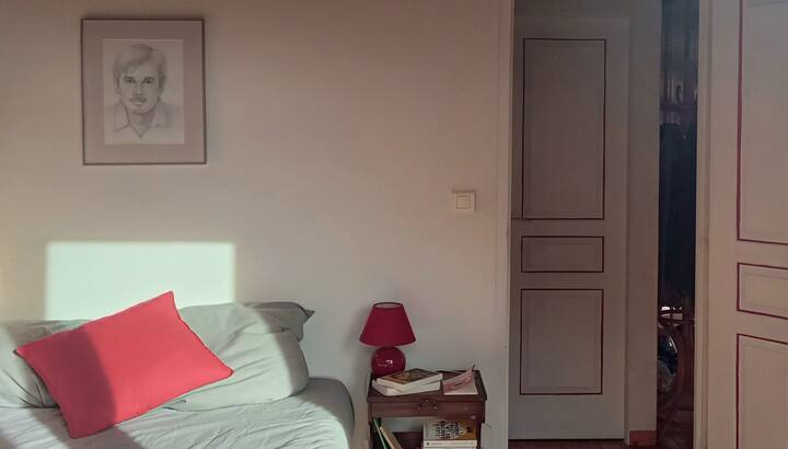 Vue de la chambre face à la porte. La chambre est à côté de la salle d'eau et des toilettes.