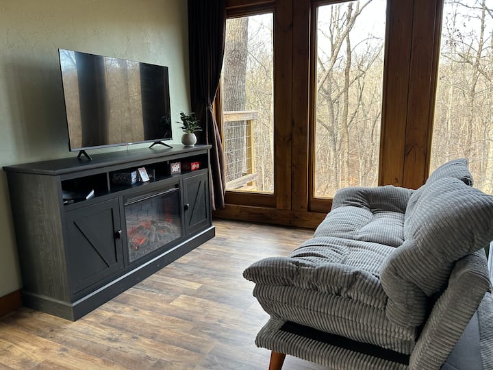 Comfy Futon Couch, Roku TV with high speed internet, beautiful electric fireplace, fun board games, 
privacy blackout curtains and beautiful forest views!
(We used re-purposed French doors for the wall of windows!)