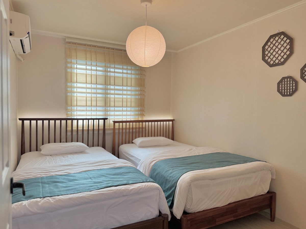 ოთახს აქვს რვაკუთხა კარი, რომელიც ორი ცალკე ერთადგილიანი საწოლისკენ მიუთითებს.