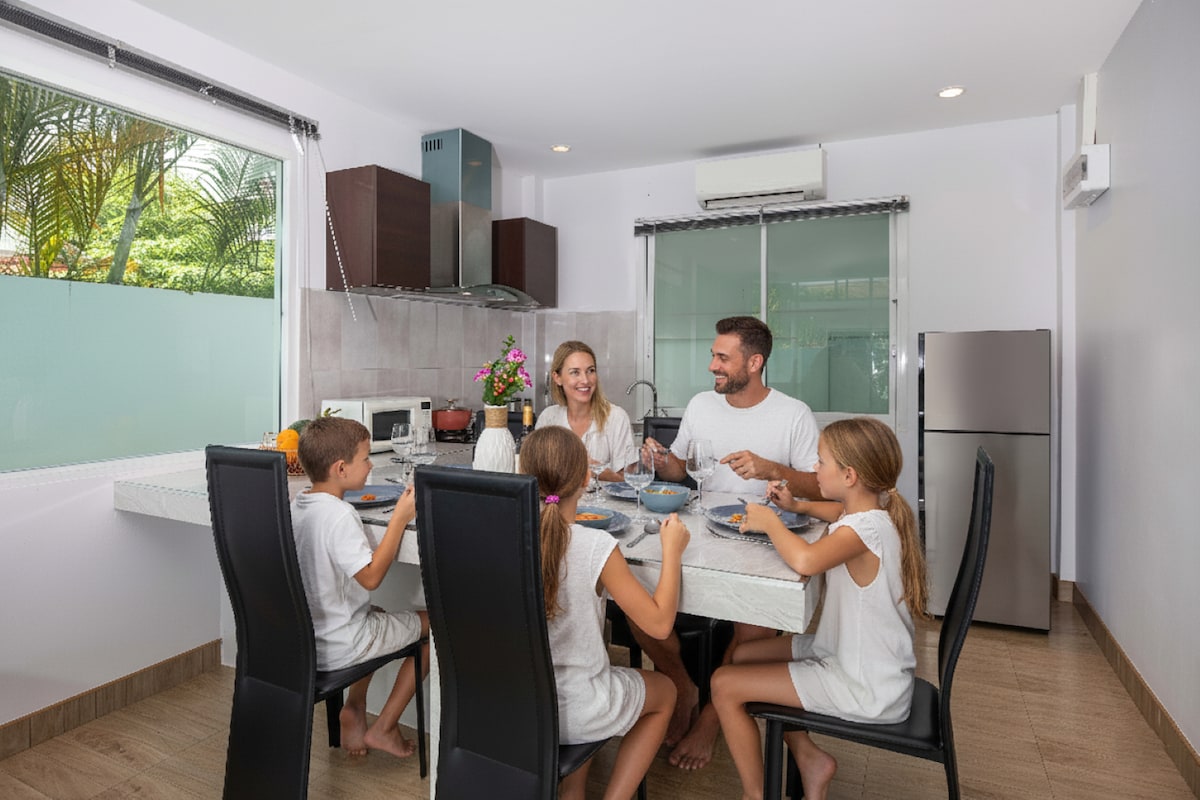 Gia đình dùng bữa trong không gian bếp và bàn ăn của villa nguyên căn